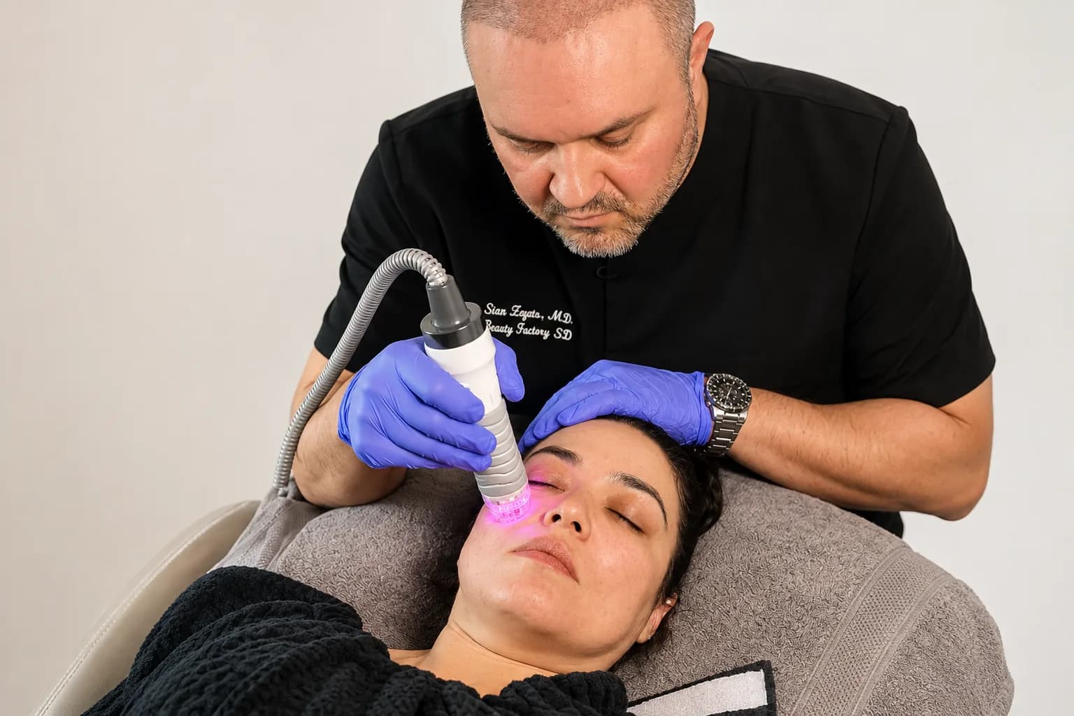 A clinician performing a treatment on a seated patient at the practice.